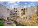 Exterior view of the condo community along a creek with wooden decks and ample natural light at 6700 W 11Th Ave # 202, Lakewood, CO 80214