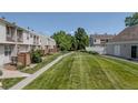 Well-maintained community grounds with lush grass, mature trees, and walking path at 4262 E Maplewood Way, Centennial, CO 80121
