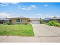 Well-kept single-story home boasts a green lawn and ample driveway leading to an attached two-car garage at 6987 E Wyoming Pl, Denver, CO 80224