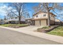 A charming two-story home with a two-car garage, complemented by a well-maintained lawn and mature trees at 4381 S Estes St, Littleton, CO 80123