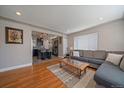 Open concept living room with hardwood floors seamlessly connects to a modern kitchen and in-unit laundry at 4530 S Pennsylvania St, Englewood, CO 80113