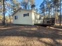 Back exterior of home showing a cozy deck and lots of privacy surrounded by a lovely treed property at 36351 County Road 21, Elizabeth, CO 80107