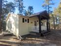 Side exterior of home featuring a quaint front porch perfect for enjoying the peaceful, wooded surroundings at 36351 County Road 21, Elizabeth, CO 80107
