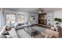 Inviting living room boasts a fireplace with built-in shelving, neutral-toned furniture, and ample natural light at 53 S Eagle Cir, Aurora, CO 80012