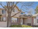 Inviting brick and tan two-story home with a well-maintained front yard and a charming covered entryway at 112 W Sterne Pkwy, Littleton, CO 80120