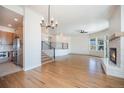 Open living room and staircase featuring hardwood floors, a fireplace, and access to the kitchen at 7077 Ammons St, Arvada, CO 80004