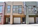 Three modern townhouses, each with unique siding and attached garages, offer urban living at 2147 N Downing St, Denver, CO 80205