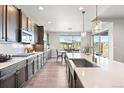 Bright open kitchen with stainless steel appliances, large center island, and backyard views at 7950 Piney River Ave, Littleton, CO 80125