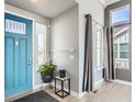 Inviting foyer showcasing a stylish front door, light gray walls, hardwood floors and lots of natural light at 4628 Mt Shavano St, Brighton, CO 80601