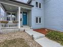 Home exterior featuring a blue front door, covered front porch with seating, and tasteful landscaping at 4628 Mt Shavano St, Brighton, CO 80601