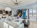 Bright living room with a large sectional, hardwood floors, a ceiling fan and lots of natural light at 4628 Mt Shavano St, Brighton, CO 80601