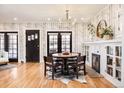 Elegant dining room with a modern chandelier, fireplace, and hardwood floors at 1453 S Lafayette St, Denver, CO 80210