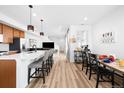 Open-concept kitchen and dining area with modern finishes and a breakfast bar at 47 N Uriah St, Aurora, CO 80018