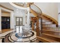 Grand foyer featuring a swirling staircase, a starburst-patterned marble floor, and soaring ceilings at 115 S Jasmine St, Denver, CO 80224