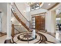 Elegant foyer boasts a spiral staircase, a starburst-patterned floor, and a custom front door at 115 S Jasmine St, Denver, CO 80224