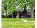 Charming home with black brick, green lawn, sidewalk, and a cozy outdoor seating area at 1218 S University Blvd, Denver, CO 80210