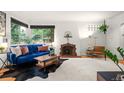 Living room with a vintage brick fireplace, large windows, and a comfortable blue velvet sofa at 1218 S University Blvd, Denver, CO 80210
