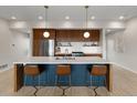 Stylish kitchen showcasing a large island, seating, modern pendant lights, and stainless steel appliances at 3233 Tejon St # 305, Denver, CO 80211