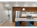 Modern kitchen featuring a large island, stainless steel appliances, wood cabinetry and modern lighting at 3233 Tejon St # 305, Denver, CO 80211