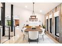 Bright dining room with modern light fixture, wood accent wall, and stylish decor at 18910 Augusta Dr, Monument, CO 80132