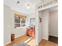 Cozy entryway featuring hardwood floors, a colorful cabinet, and a view of the neighborhood through the window at 439 S Reed Ct, Lakewood, CO 80226