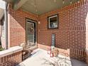 Inviting front porch featuring brick accents, a welcome sign, and decorative lanterns, creating a warm entrance at 439 S Reed Ct, Lakewood, CO 80226