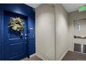 Condo entrance featuring a blue door adorned with a decorative wreath at 85 Rampart Way # 206, Denver, CO 80230
