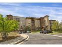 Exterior shot of condo building and parking area, showing a well-designed landscape at 85 Rampart Way # 206, Denver, CO 80230