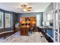 Spacious home office with custom built-ins, dark wood floors, and ample natural light at 2460 Switch Grass Way, Castle Rock, CO 80109