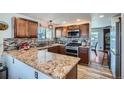 Beautiful kitchen featuring granite countertops, stainless steel appliances, and wood cabinets at 5251 Altura St, Denver, CO 80239