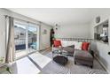 Inviting living room features a sliding glass door with a small balcony, creating a sunny space at 1225 S Oneida St # 248, Denver, CO 80224