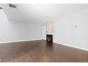 Open-concept living room with wood floors and brick fireplace at 2366 S Troy St, Aurora, CO 80014