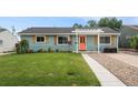 Charming single-story home with a manicured lawn, inviting walkway, and vibrant blue siding at 1892 S Meade St, Denver, CO 80219