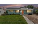 Charming single-story home featuring a well-maintained lawn and an inviting orange front door at 1892 S Meade St, Denver, CO 80219