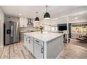 Modern kitchen with large island, stainless steel appliances, and open floor plan to the living area at 1892 S Meade St, Denver, CO 80219