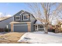 Charming two-story home featuring blue siding, brick accents, and an attached two-car garage at 16313 Roan Ct, Parker, CO 80134