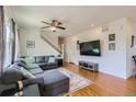 Bright living room with hardwood floors and a large sectional sofa at 10023 Uravan St, Commerce City, CO 80022