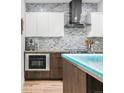 Updated kitchen with stainless steel appliances, unique glass island, and stylish backsplash at 3295 Blake St # 102, Denver, CO 80205