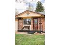 Close-up of the home's front porch featuring a cozy bench and decorative door at 822 S Worchester St, Aurora, CO 80012
