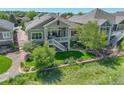 Expansive backyard featuring a multi-level patio, lush lawn, and landscaped garden area at 14879 Xenia St, Thornton, CO 80602
