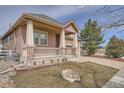Inviting home with a covered front porch and well-maintained landscaping at 1260 S Duquesne Cir, Aurora, CO 80018