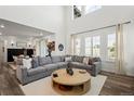 Bright and airy living room features soaring ceilings, large windows, and a comfortable gray sectional at 17121 Desert Wine Ln, Parker, CO 80134