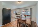 Dining room with wooden table and chairs, hardwood floors, and sliding glass doors to the backyard at 3148 Victor St, Aurora, CO 80011