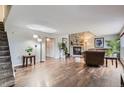 Spacious living room with hardwood floors and a stone fireplace, perfect for relaxing and entertaining guests at 10779 Longs Way, Parker, CO 80138