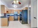 Updated kitchen featuring wood cabinets, granite countertops, and black appliances at 3082 S Wheeling Way # 408, Aurora, CO 80014