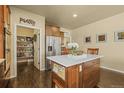 Bright kitchen featuring an island, pantry, stainless steel refrigerator and modern finishes at 19814 Lindenmere Dr, Monument, CO 80132