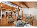 Open-concept living room featuring hardwood floors, exposed beams, and a cozy seating arrangement at 78 Fairway Ln, Littleton, CO 80123