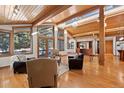 Spacious living room boasts wood-beam ceiling, hardwood floors, and lots of natural light from large windows at 78 Fairway Ln, Littleton, CO 80123