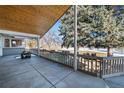 Covered patio with an outdoor fireplace overlooks the landscaped backyard at 78 Fairway Ln, Littleton, CO 80123