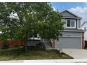 Charming two-story home with gray exterior, landscaped yard, and mature tree in the front at 378 Benton St, Castle Rock, CO 80104